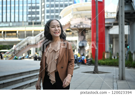 Elegant middle aged businesswoman in stylish suit walking through downtown Elegant middle aged businesswoman in stylish suit walking through downtown 120023394