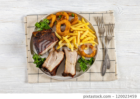 Baked pork ribs with onion rings and french fries Baked pork ribs with onion rings and french fries 120023459