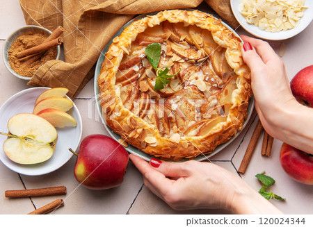 Apple galette preparation with fresh ingredients and spices on a kitchen countertop Apple galette preparation with fresh ingredients and spices on a kitchen countertop 120024344