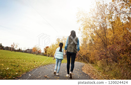 Mom, back and holding hands with child for walk, bonding or outdoor adventure on journey in nature. Rear view of mother strolling with daughter, kid or little girl for sidewalk, autumn season or park 120024424