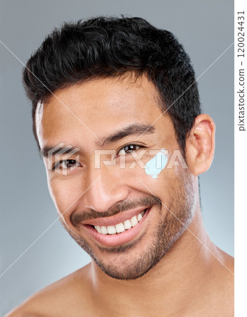 Man, studio and facial portrait with moisturizer for skincare or wellness, beauty or lotion cosmetic for aesthetics. Male person, cream and face with happiness on gray background, glow or smile Man, studio and facial portrait with moisturizer for skincare or wellness, beauty or lotion cosmetic for aesthetics. Male person, cream and face with happiness on gray background, glow or smile 120024431