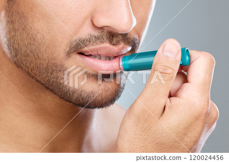 Man, lip balm and mouth in studio for beauty, skincare and cosmetics on white background. Stick, product and moisture and chapped in winter, male person and beard for dermatology treatment closeup Man, lip balm and mouth in studio for beauty, skincare and cosmetics on white background. Stick, product and moisture and chapped in winter, male person and beard for dermatology treatment closeup 120024456