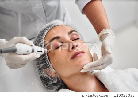 Woman receiving facial treatment at a spa during a relaxing session Woman receiving facial treatment at a spa during a relaxing session 120025053