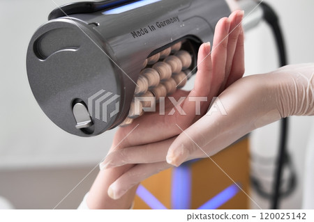 Hand treatment session with a specialized device in a clinical setting 120025142