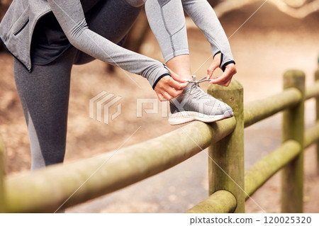Hands, runner and person with shoelace in nature on wood fence for training, exercise or workout in morning. Athlete, shoes or sneakers with preparation for fitness, health and speed in countryside Hands, runner and person with shoelace in nature on wood fence for training, exercise or workout in morning. Athlete, shoes or sneakers with preparation for fitness, health and speed in countryside 120025320