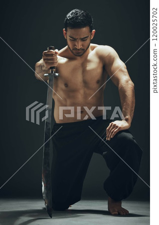 Asian man, kneeling and ninja sword in studio for wellness, calm and exercise for martial arts. Blade, training and self defense by black background for karate and battle for samurai in dojo or Japan Asian man, kneeling and ninja sword in studio for wellness, calm and exercise for martial arts. Blade, training and self defense by black background for karate and battle for samurai in dojo or Japan 120025702