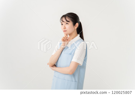 Woman in apron, nursery teacher, caregiver, worries Woman in apron, nursery teacher, caregiver, worries 120025807