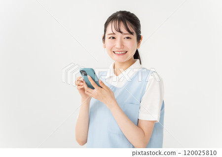 圍裙的女人、托兒所老師、護理人員、智慧型手機 圍裙的女人、托兒所老師、護理人員、智慧型手機 120025810