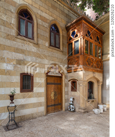 Traditional Stone Building With Ornate Wooden Balcony and Doorway Traditional Stone Building With Ornate Wooden Balcony and Doorway 120026210
