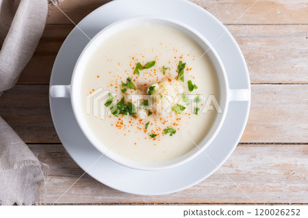 Cauliflower soup in bowl on wooden table Cauliflower soup in bowl on wooden table 120026252