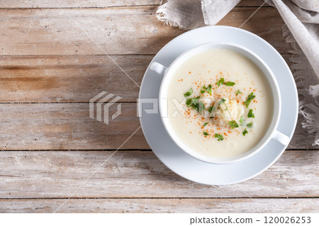 Cauliflower soup in bowl on wooden table 120026253
