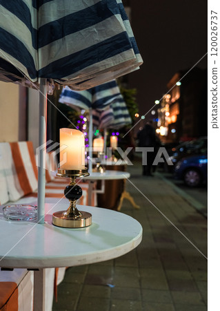 Tables of an outdoor restaurant. The candle is on the table. Minsk nightlife 120026737