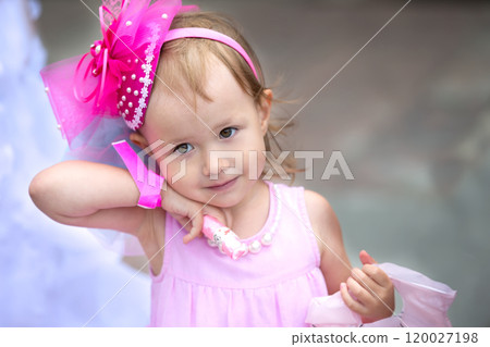 Embarrassed little girl in a pink dress. 120027198