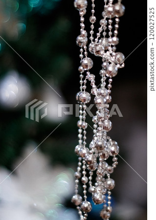 Silver christmas beads hanging on decorated christmas tree. New Year 2025 120027525