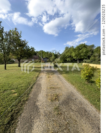 path or road in the countryside leads to village 120028235