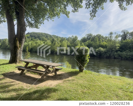 empty wooden picnic table in the park by river 120028236