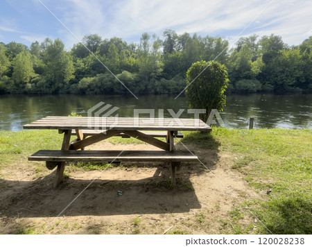 empty wooden picnic table in the park by river 120028238