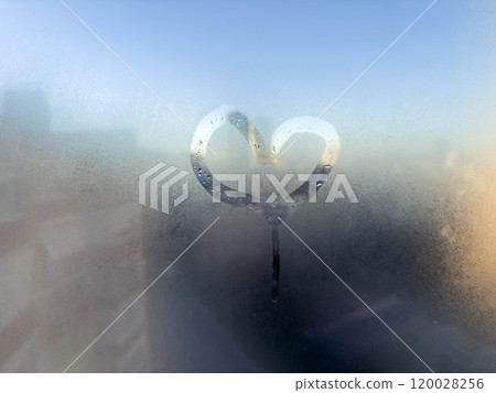 hand drawn heart shape on steamed window glass 120028256