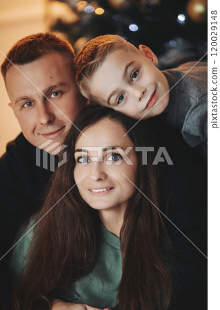 A family around the Christmas tree in the new year 120029148
