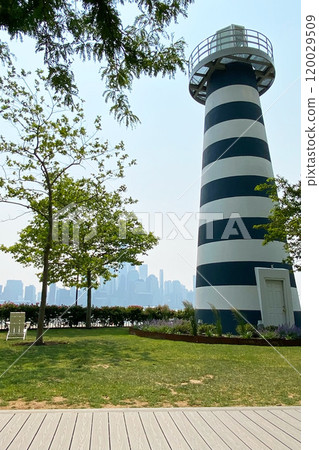 Green lawn of the park with a decorative lighthouse 120029509