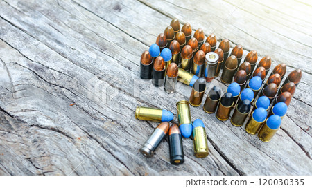 Various types of bullets displayed on a wooden surface, symbolizing the theme of firearm safety, the impact of violence, and the importance of responsible use and control of firearms. Various types of bullets displayed on a wooden surface, symbolizing the theme of firearm safety, the impact of violence, and the importance of responsible use and control of firearms. 120030335