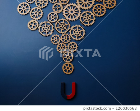 Magnet and wooden gear on a blue background. 120030568
