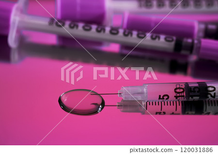 Injection syringes on a medical tray in bright pink color. 120031886