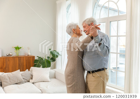 Keep moving. Romantic senior mature couple dancing to music together at home. Happy smiling family retired man woman husband wife having fun enjoying time together. Family moment love care Keep moving. Romantic senior mature couple dancing to music together at home. Happy smiling family retired man woman husband wife having fun enjoying time together. Family moment love care 120031939
