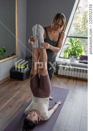 Yoga Instruction Exploring the Enhanced Partner Stretching Technique with in a Studio. Inversion pose to enhance flexibility and balance 120032358