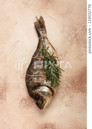 hot smoked dorado fish, with a sprig of rosemary, tied with a rope, on the table, top view, smoked fish, close-up, no people, 120032776