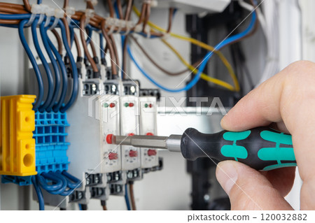 Hand Using Screwdriver on Electrical Terminal Block Hand Using Screwdriver on Electrical Terminal Block 120032882