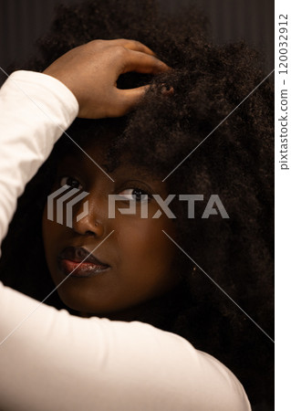 Portrait of a Woman with Curly Hair in a White Sweater looking thoughtful and elegant Portrait of a Woman with Curly Hair in a White Sweater looking thoughtful and elegant 120032912