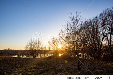 A Serene and Beautiful Sunset Over Calm and Tranquil Waters, Surrounded by Lush Trees A Serene and Beautiful Sunset Over Calm and Tranquil Waters, Surrounded by Lush Trees 120032921