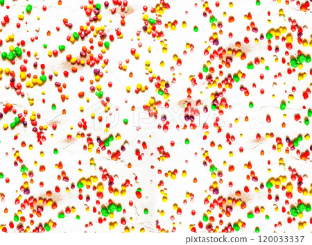 Rainbow colored candy sprinkled on a white background 120033337