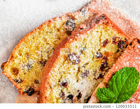 Traditional cake with raisins sprinkled with powdered sugar and mint leaves decorated. 120033511