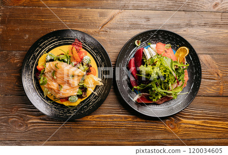 Gourmet salad plates with smoked salmon, fresh greens, and vibrant garnishes on rustic wooden table Gourmet salad plates with smoked salmon, fresh greens, and vibrant garnishes on rustic wooden table 120034605
