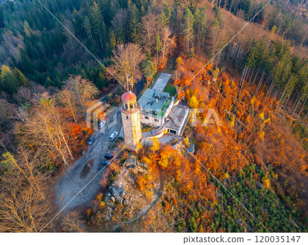 The lookout tower on Prosec Ridge near Jablonec nad Nisou stands surrounded by vibrant autumn foliage during a serene sunset, offering breathtaking views of the Jizera Mountains. The lookout tower on Prosec Ridge near Jablonec nad Nisou stands surrounded by vibrant autumn foliage during a serene sunset, offering breathtaking views of the Jizera Mountains. 120035147