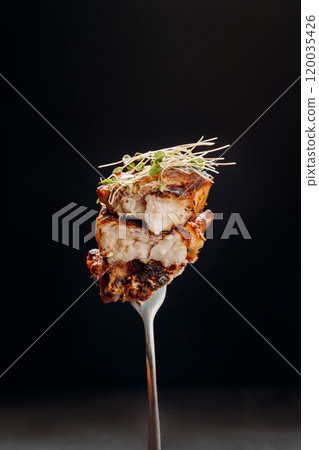 Grilled chicken piece garnished with microgreens, perfect for gourmet presentations or food displays Grilled chicken piece garnished with microgreens, perfect for gourmet presentations or food displays 120035426