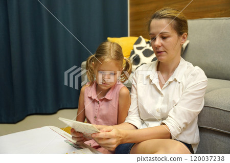 A mother supports her daughter with homework 120037238