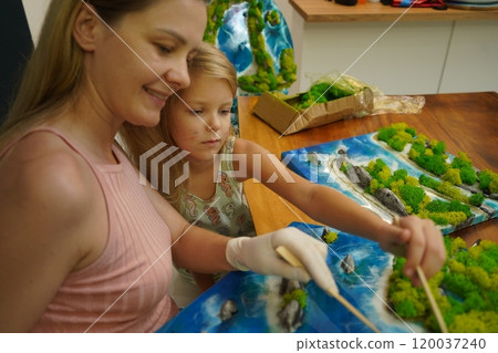A mother and her daughter craft vibrant natural landscapes  120037240