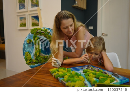 A mother and her daughter craft vibrant natural landscapes  120037246
