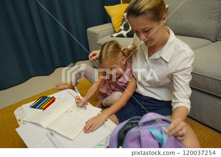 A mother supports her daughter with homework A mother supports her daughter with homework 120037254