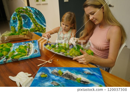 A mother and her daughter craft vibrant natural landscapes  120037308