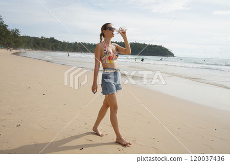 A young woman enjoying a beautiful day at the beach  120037436