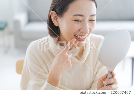 Woman checking her mouth in the mirror Woman checking her mouth in the mirror 120037467