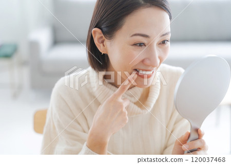 一個女人在鏡子裡檢查自己的嘴 120037468