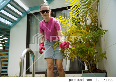 A young woman trims her beautiful garden  120037490