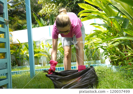 A young woman trims her beautiful garden  120037499