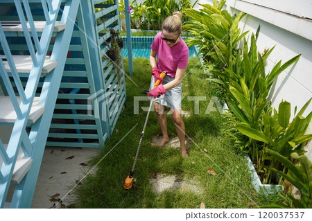 A young woman trims her beautiful garden  120037537