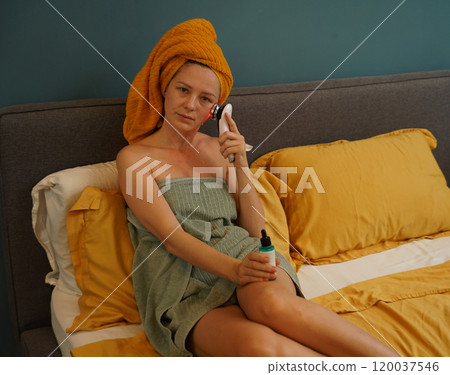 Young woman using infrared massager  120037546